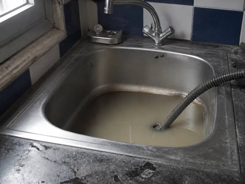 Fregadero con agua retenida en una cocina del Cabanyal durante el desatasco del desagüe